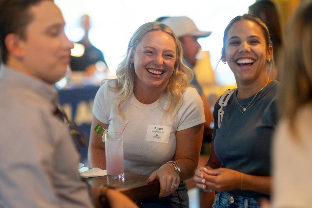 Two women smiling at someone they are talking to